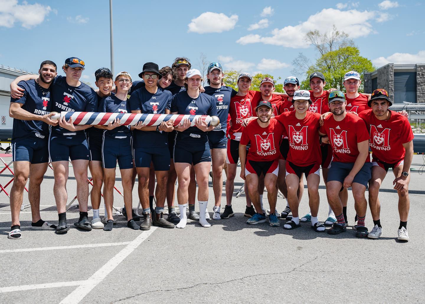 The team of the UofT men's 'Blue Boat' eight crew (including myself) holding the championship barber pole trophy alongside rival McGill University's 'Red Boat' crew at the Montréal Olympic Basin, Québec.